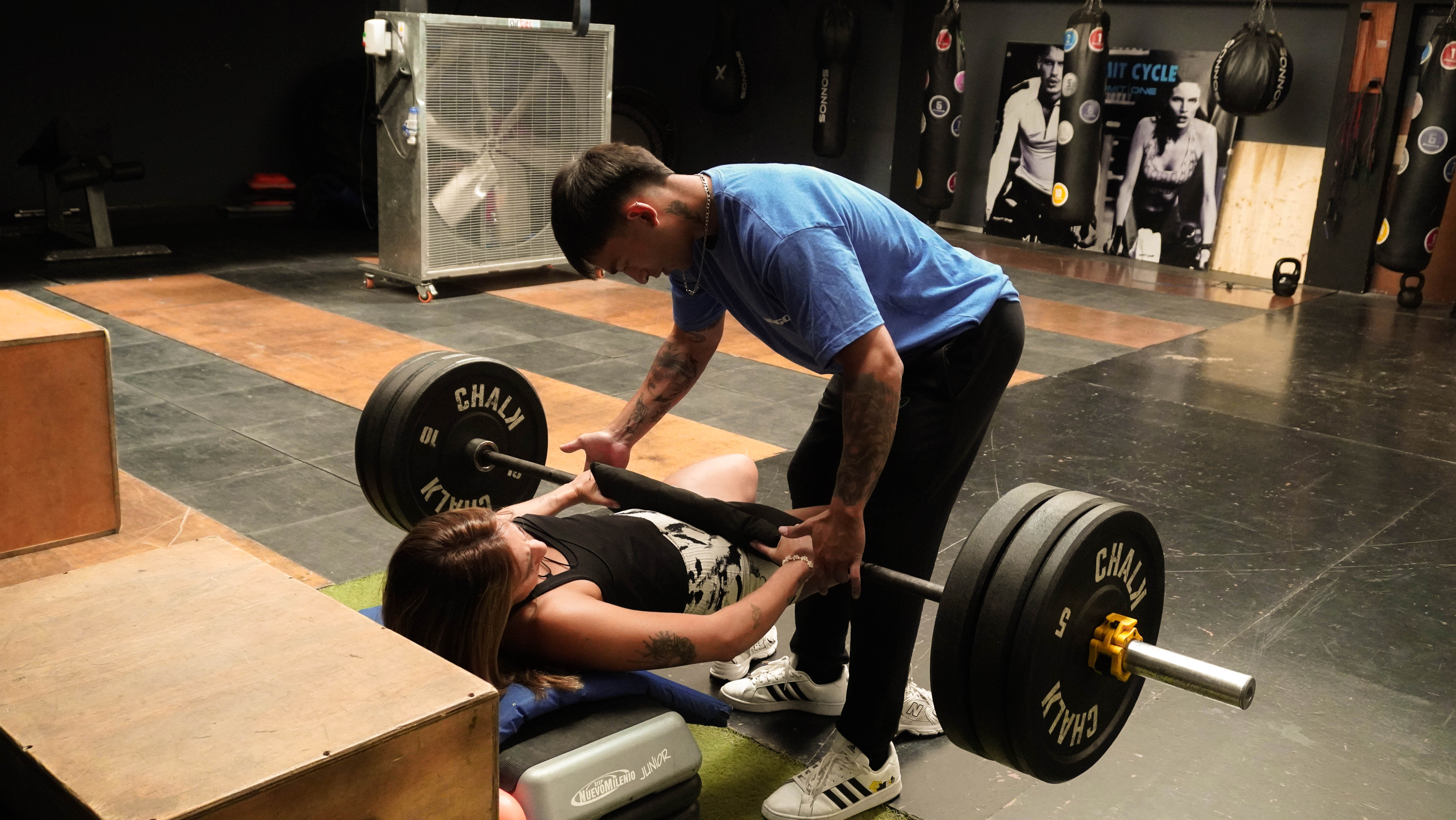 Muscular back of a man training in a dark gym
